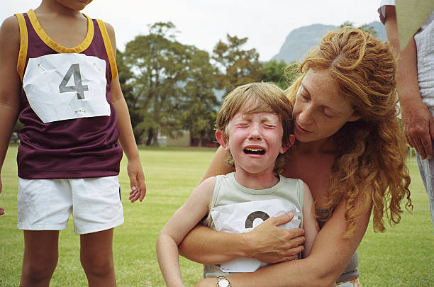 Child crying and being comforted by adult.